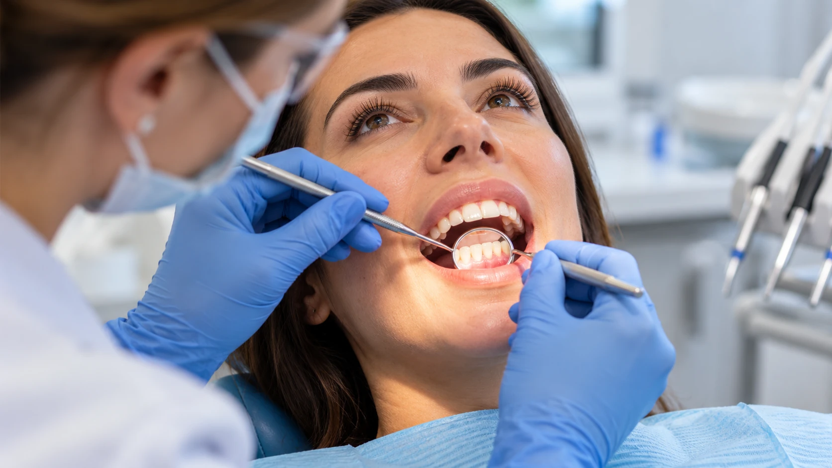 Profesional dental examinando las encías de una paciente con espejo dental durante una valoración